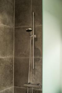 a shower in a bathroom with a tile wall at Hotel Alte Post Flensburg in Flensburg