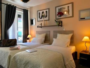 パリにあるホテル クレールフォンテーヌのベッドルーム1室(ベッド2台、窓付)