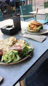 a table with two plates of food and a sandwich at B&B boerderij rust, in pipowagens! in Den Helder