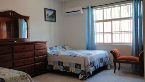 1 dormitorio con 1 cama, vestidor y ventana en Posada Nativa Miss Nova, en San Andrés