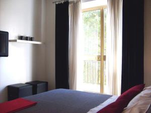 1 dormitorio con cama y ventana grande en I Cugi Metropolis, en Bronte
