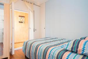 a bedroom with a bed with a striped comforter at Sunny Apartments in Sitges