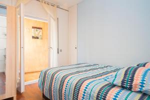 1 dormitorio con 1 cama con edredón a rayas en Sunny Apartments, en Sitges