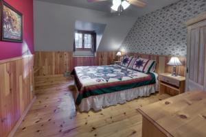a bedroom with a bed and a wooden floor at Les Chalets sur le Cap in Saint-Joachim