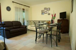 a living room with a table and chairs and a couch at Our Little House in Vila Real de Santo António