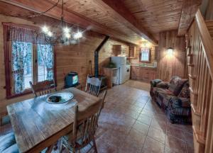 a dining room and kitchen in a log cabin at Les Chalets sur le Cap in Saint-Joachim