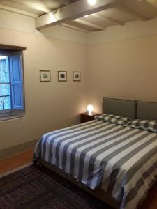 - une chambre avec un lit rayé et une fenêtre dans l'établissement La Breccia di Anghiari, à Anghiari