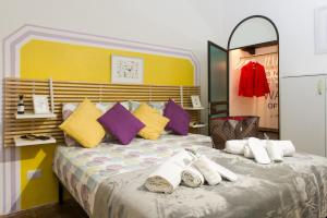 una camera da letto con un letto grande con cuscini colorati di STELLA'S APARTMENT IN MONTI a Roma
