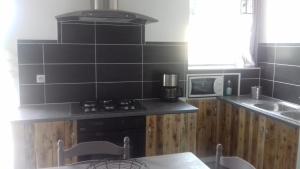 a kitchen with black tile walls and a stove top oven at Cagouille in Vix