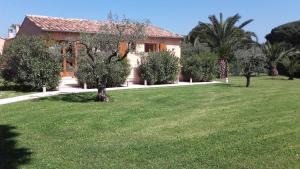 グリモーにあるChambres d'hôtes Villa Alizéの木々と芝生の家