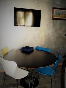 mesa con sillas y TV en la pared en rubino home, en Sestri Levante