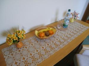 einen Tisch mit einer Schale Obst und einer Flasche Wasser in der Unterkunft Ferienhaus Müller in Unkel