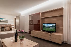 Televízia a/alebo spoločenská miestnosť v ubytovaní Apartments Tschanun