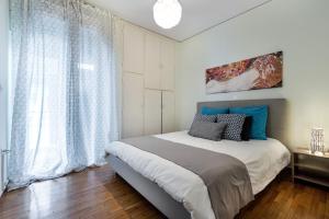 雅典的住宿－雅典衛城精品套房公寓，一间卧室设有一张床和一个大窗户
