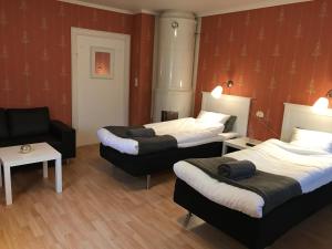 a hotel room with two beds and a chair at Skärplinge Gästis B&B in Skärplinge