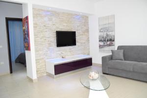 a living room with a couch and a tv on a brick wall at VillAcri in Acri