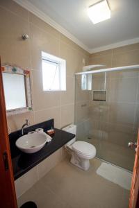 a bathroom with a toilet and a sink and a shower at Pousada Acqua Azul in Bertioga