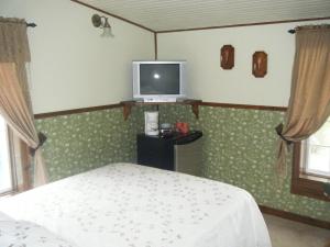 Saint-Gabriel-de-BrandonにあるAuberge le St-Gabのベッドルーム1室(ベッド1台、壁掛けテレビ付)