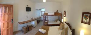 a living room with a couch and a room with a staircase at Pousada Acqua Azul in Bertioga