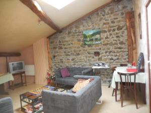 ein Wohnzimmer mit einem Sofa und einer Steinmauer in der Unterkunft Hotel Magne in Saurier