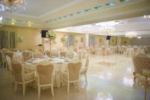 a banquet hall with white tables and chairs and chandeliers at Hotel Elita in Odesa +102 photos