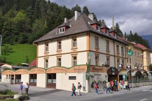 a group of people standing outside of a large building at Brauhaus Falkenstein in Lienz