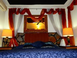 a bedroom with a bed with a mirror and two lamps at Hotel Torres Del Fuerte in El Fuerte