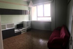 sala de estar con sofá rojo y TV en Juventus (Allianz) stadium apartment, en Turín