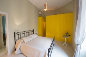 ナポリにあるDuomo Regina Apartmentsの黄色の壁のベッドルーム1室