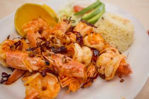 a plate of shrimp with a side of rice and a lime at Hotel Colonial in Manzanillo