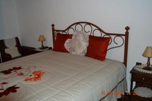 1 dormitorio con 1 cama con almohadas rojas en Casa da Maria en Monsanto