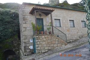 un edificio de piedra con una puerta con plantas. en Casa da Maria en Monsanto