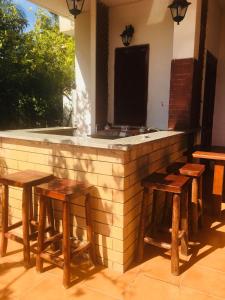 モンドラゴーネにあるCasa vacanza villa Ritaのカウンター前の木製スツール付きのバー