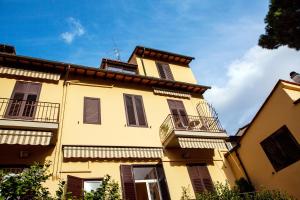 un bâtiment jaune avec des volets noirs et un balcon dans l'établissement Hotel Villa Il Castagno, à Florence