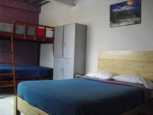 a bedroom with a bed and two bunk beds at Kelebek Hostel in Lima