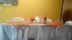 un tavolo con sedie bianche e una torta sopra di Cabana hotel eco turistico el EDEN a Güicán