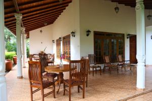 comedor con mesa y sillas en el patio en Villa Anna, en Hikkaduwa