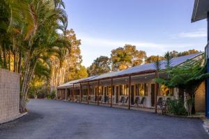 a building with a lot of windows and palm trees at Tin Can Bay Motel in Tin Can Bay