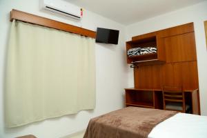 
a bedroom with a bed and a television at Hotel Petrov in Canela
