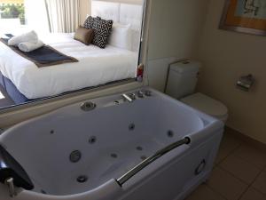 a white bath tub sitting in a bathroom next to a window at Diamond Island Resort & Bicheno Penguin Show in Bicheno