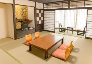 uma sala de estar com uma mesa de madeira e cadeiras em Ishicho em Quioto