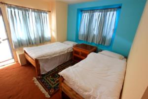 سرير أو أسرّة في غرفة في Himalayan Lodge