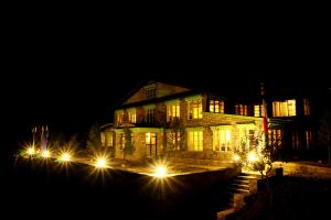 une maison avec des lumières devant elle la nuit dans l'établissement Mountain Lodges of Nepal - Monjo, à Monjo