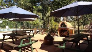 a patio with tables and umbrellas and a grill at Parry Creek Farm Tourist Resort and Caravan Park in Wyndham