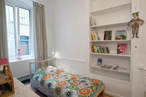 a bedroom with a bed and shelves with books at " Martin Schongauer " in Colmar