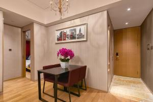 a dining room with a vase of flowers on a table at Heefun International Apartment - Zhujiang New Town FuLi Brand New World Plaza in Guangzhou