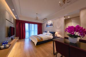um quarto com uma cama e um vaso de flores em Heefun Apartment Guangzhou - FuLi Brand New World Plaza em Guangzhou