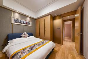 um quarto com uma cama grande e uma cabeceira azul em Heefun Apartment Guangzhou - FuLi Brand New World Plaza em Guangzhou