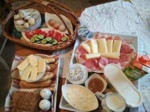 einen Tisch mit Käse, Fleisch und anderen Lebensmitteln in der Unterkunft Apartment-Chalet-Chaloupka U Trnků in Lázně Kynžvart