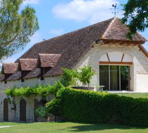 een oud stenen huis met een groot raam bij Belveyre à Rocamadour in Rocamadour